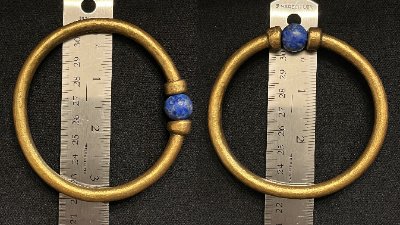 The replica gold bracelet measured against a ruler to document its 3.5-inch overall diameter.