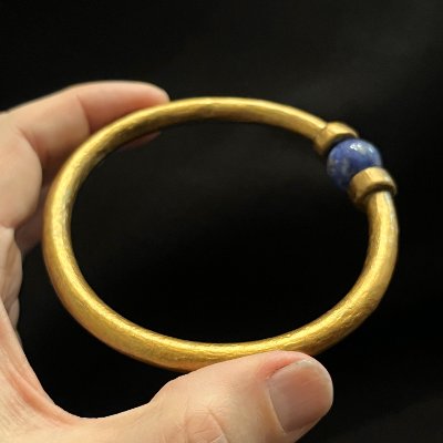 Angled perspective of the rigid replica bracelet highlighting the central lapis lazuli stone.