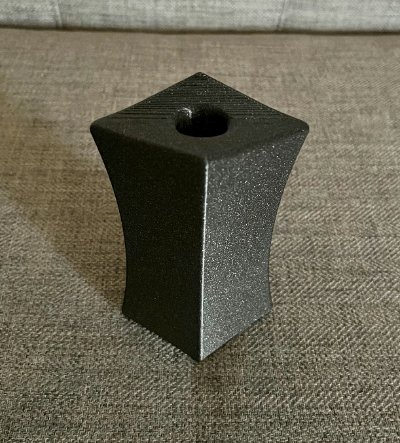The black composite replica bannerstone standing upright on a flat surface.