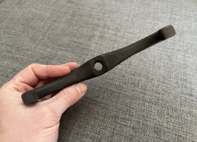 Handheld view displaying the elongated span and central perforation of the knobbed replica.