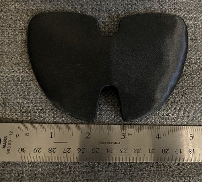 Top-down view of the black bannerstone positioned flat against a metal ruler to verify span.