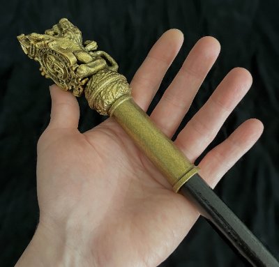 Hand supporting the lion rampant headpiece to show intricate sculptural details.