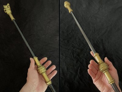 Hands holding the upper and lower halves of the replica Black Rod staff.