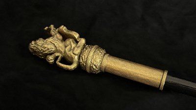 Close-up profile of the lion rampant headpiece attached to the dark oak shaft.