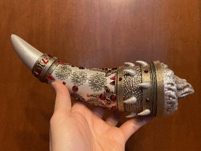 A hand holds the 12-inch Horn of Dagoth replica, illustrating its scale and jeweled details.