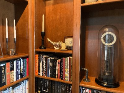 The restored Horn of Dagoth film prop replica is exhibited on a wooden library shelf.