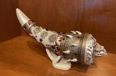 Full side profile of the Horn of Dagoth prop replica resting horizontally on a display stand.