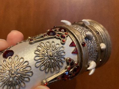 Macro view of the central horn body showing metal filigree and imported red teardrop gems.