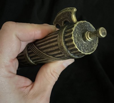 Close detail of the top finial and upper rod structure held in fingers.