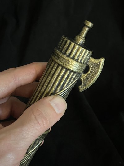 Hand firmly gripping the central section of the bound rod replica.