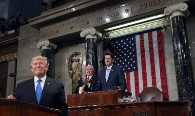 Close view of the U.S. House rostrum framed by the large wall fasces.