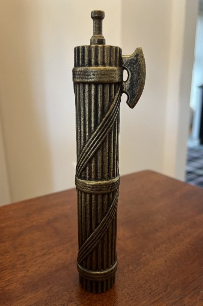 The fasces replica standing vertically on a table.