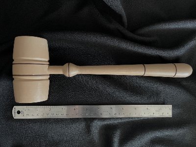 Replica House gavel positioned horizontally above a metal ruler to demonstrate its size.
