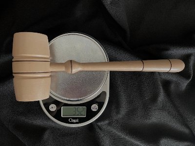 Wood replica gavel placed on a digital scale to verify its accurate weight matching the original.