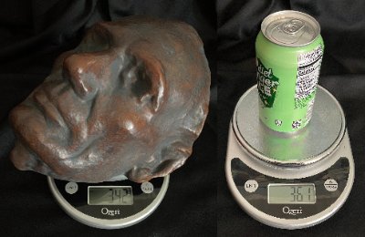 Life mask and standard aluminum can placed on separate digital scales for weight comparison.