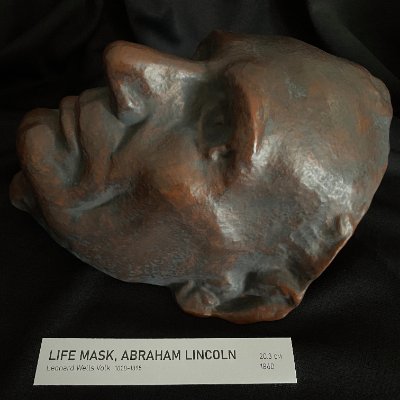 Detail view of the left profile highlighting facial texture and bronze patina finish.