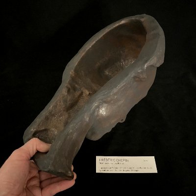 View into the hollow interior backside of the reproduction held by hand.