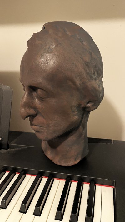 Standing orientation of the Chopin death mask placed upon a piano keyboard.