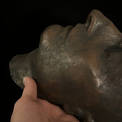 Close-up view of the chin and lower contour of the Napoleon replica held by a hand.