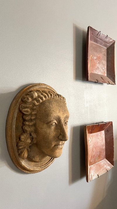 Replica displayed mounted on a wall alongside framed artwork for context.
