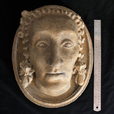 Direct anterior facial view of the effigy placed beside a metal ruler.
