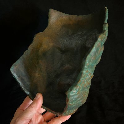 The concave interior of the mask held by a hand, showing the thin structural profile.