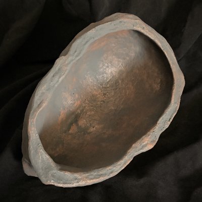 The unpolished concave interior of the cast replica resting on a surface.