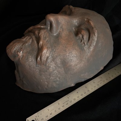 The 1616 death mask replica measured against a standard ruler for scale.