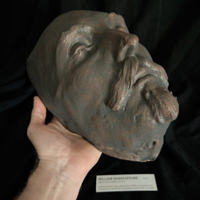 A hand holds the Kesselstadt mask replica to show scale and facial details.