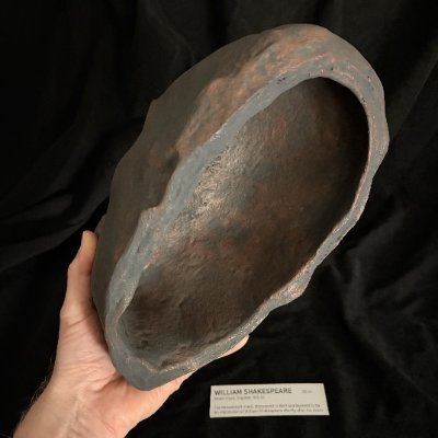 The hollow interior of the replica mask is displayed in a hand.