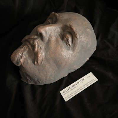High-angle view of the Shakespeare death mask replica beside its museum tag.