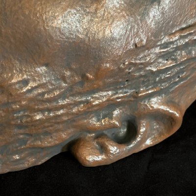 Close-up of the textured hair and left ear detail on the reconstituted limestone replica.