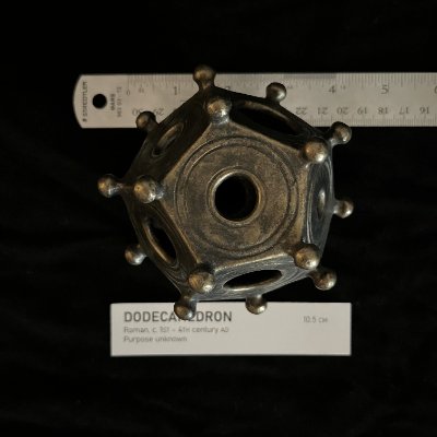 Top-down view of the replica alongside a metal ruler and label card for exact archaeological scaling.