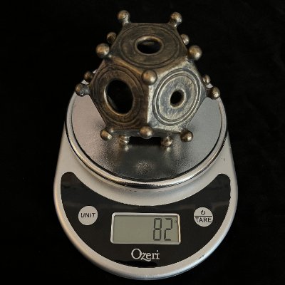 The solid composite replica is weighed on a digital scale to document its physical mass.