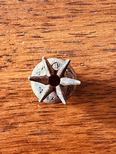 Top-down perspective of the pomegranate crown revealing the six restored petals radiating from center.