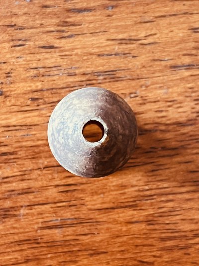 Direct view of the flat base displaying the central cylindrical mounting hole of the ivory replica.