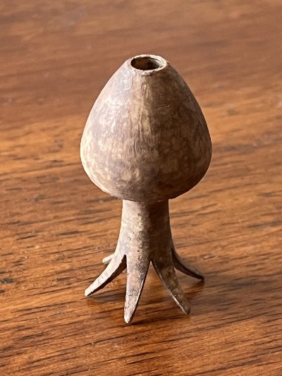 The artifact replica inverted on its crown to display the bulbous body and lower mounting aperture.