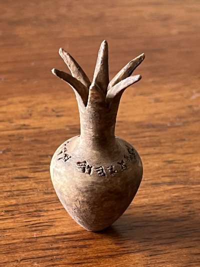 Profile view of the replica emphasizing the full ancient Hebrew inscription engraved around the neck.