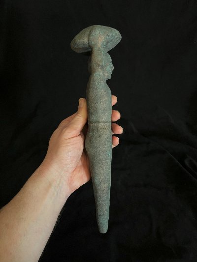 Left profile view of the full-length peg replica held in a hand.