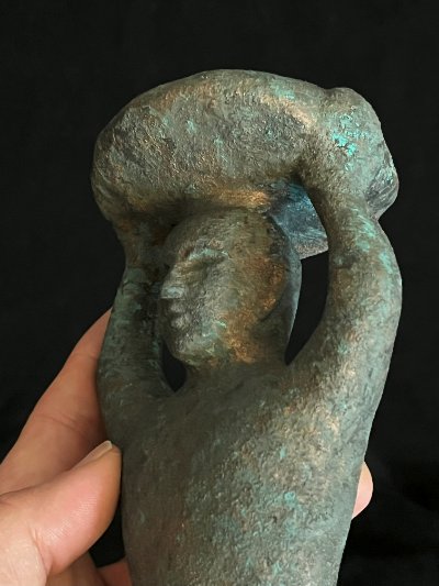 Detailed left profile of the upper torso and basket held in a hand.