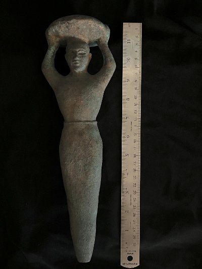The Sumerian peg replica lying flat next to a standard ruler measuring 32 cm.