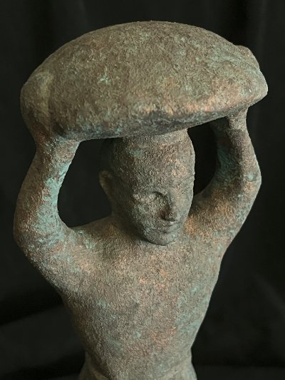 Detailed view of the oxidized limestone finish on the replica's head and basket.