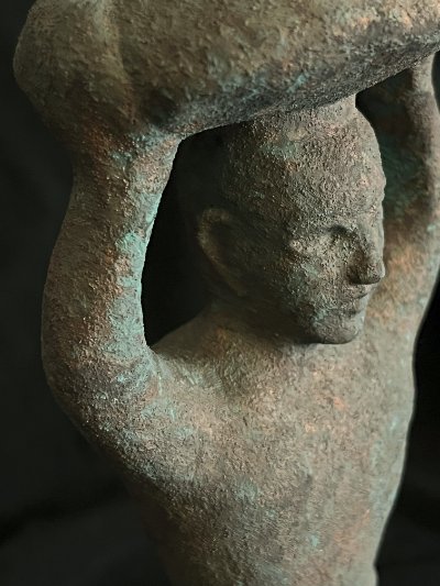 Profile view of the replica figure's head supporting the ceremonial basket.