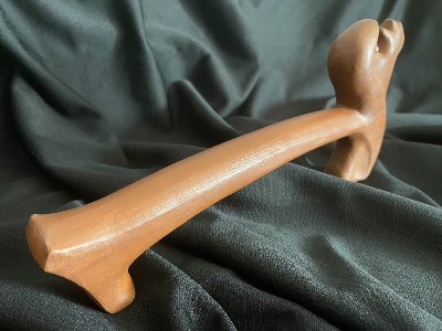 The complete wooden replica UN gavel resting horizontally on a dark textile surface.