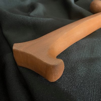 Close-up detail of the flared base on the wooden handle of the replica Gavel of Thor.