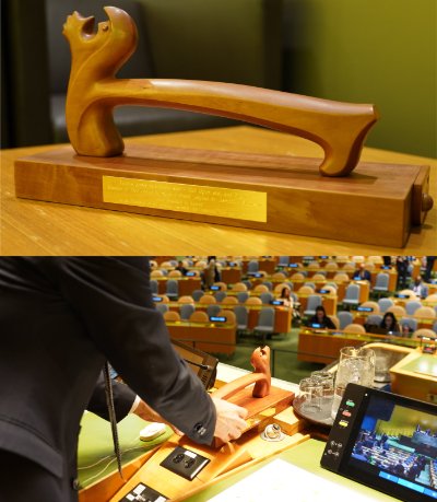 Detailed view of an official United Nations gavel resting in its custom wooden presentation stand.