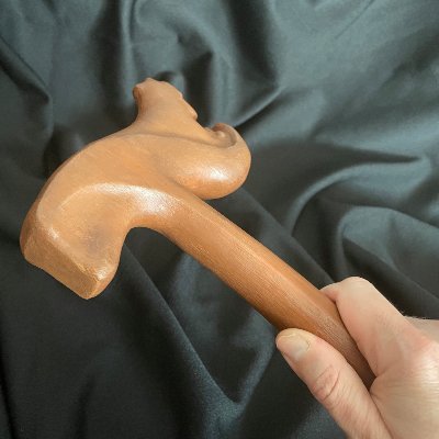 Angled view of a hand gripping the wooden handle of the replica UN Gavel of Thor.