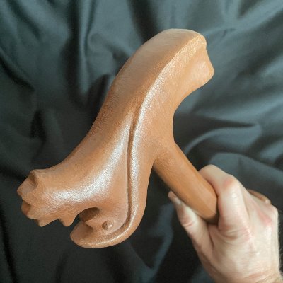 Oblique angle showing a hand holding the carved wooden replica of the UN parliamentary gavel.