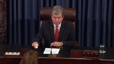 An archival photograph captures an official seated at the rostrum utilizing the original U.S. Senate gavel.