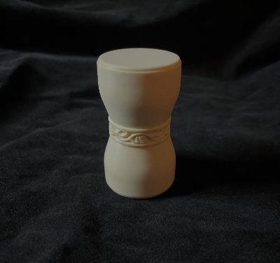 The replica U.S. Senate gavel stands vertically on a dark fabric background.